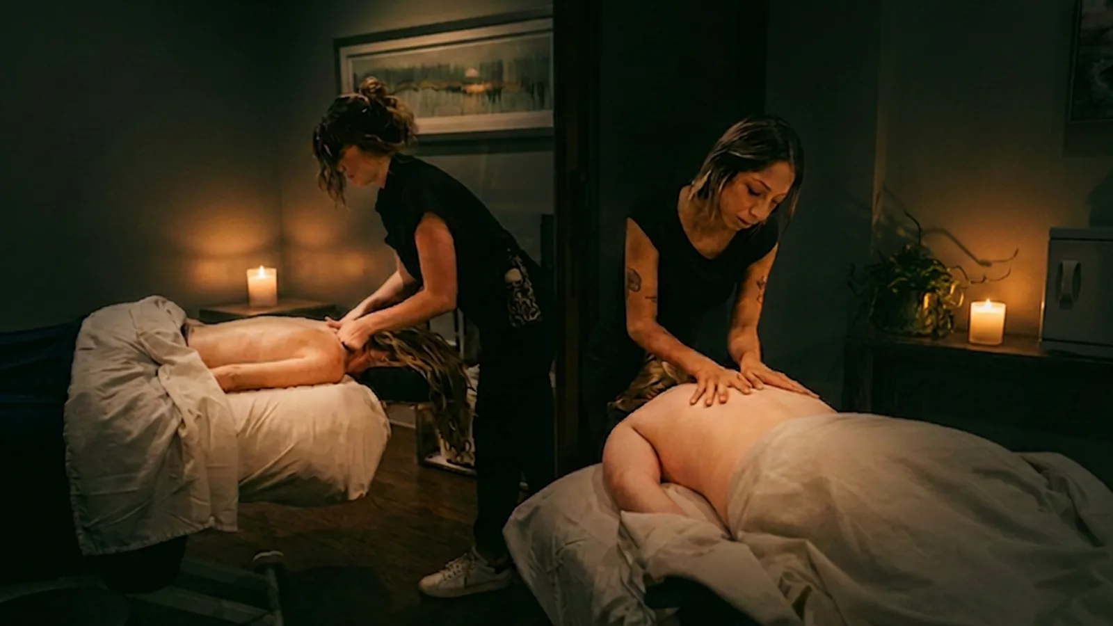 Two therapists giving a side-by-side couples massage in the private couples suite at Banyan and Bamboo, South Lamar Austin TX