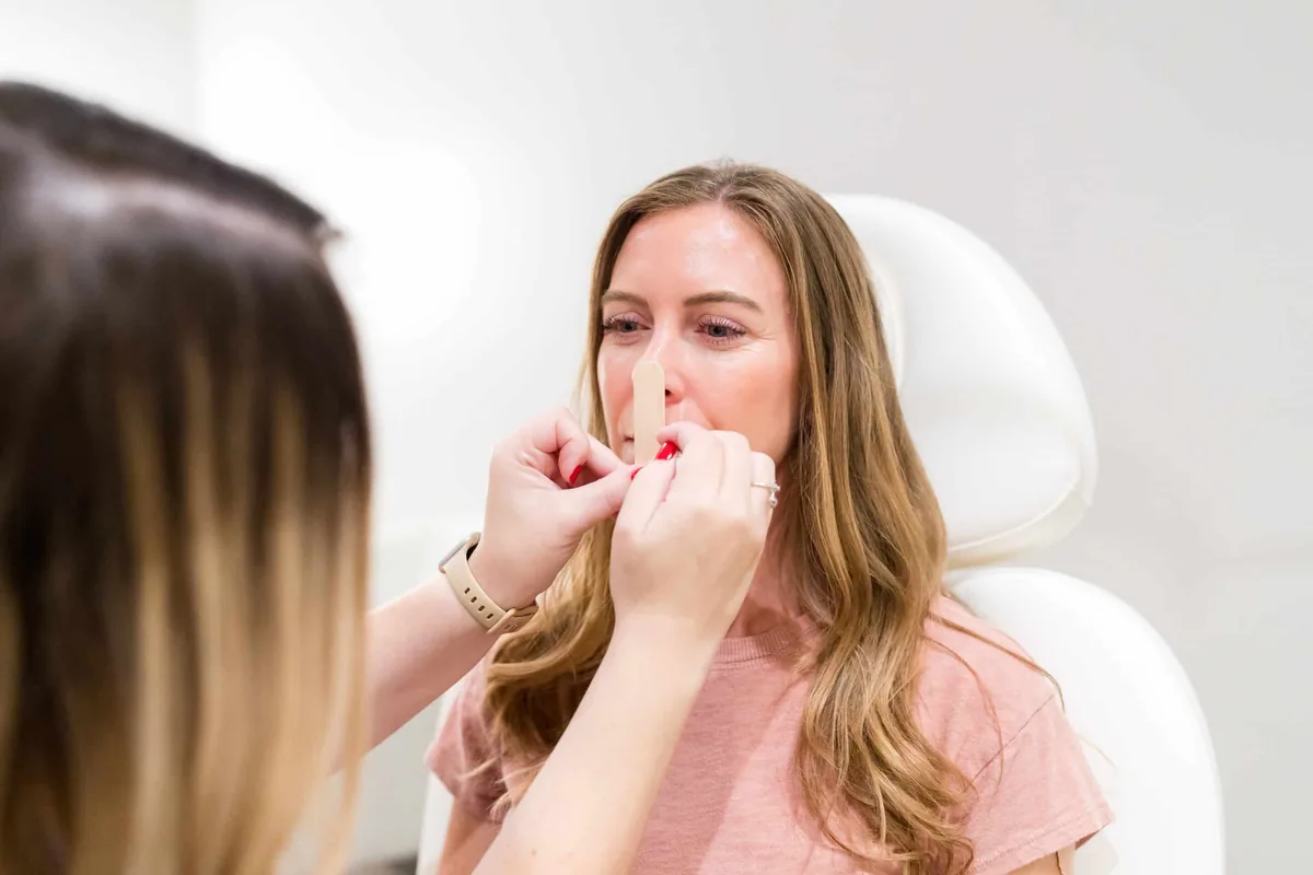 Brittany Cantu measuring facial proportions during a consultation at Banyan & Bamboo