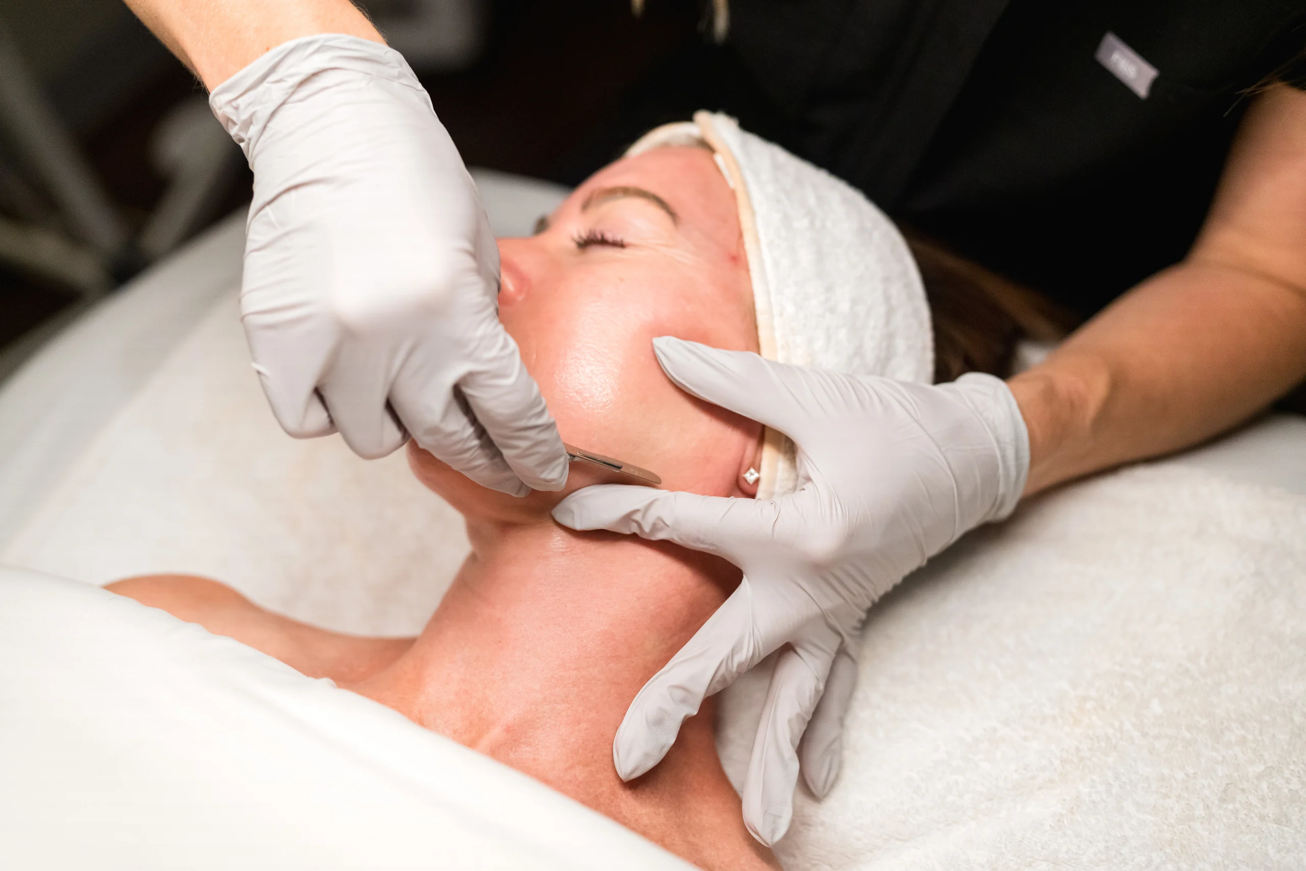 Dermaplaning facial with a surgical blade along the jawline at Banyan and Bamboo, South Lamar Austin TX