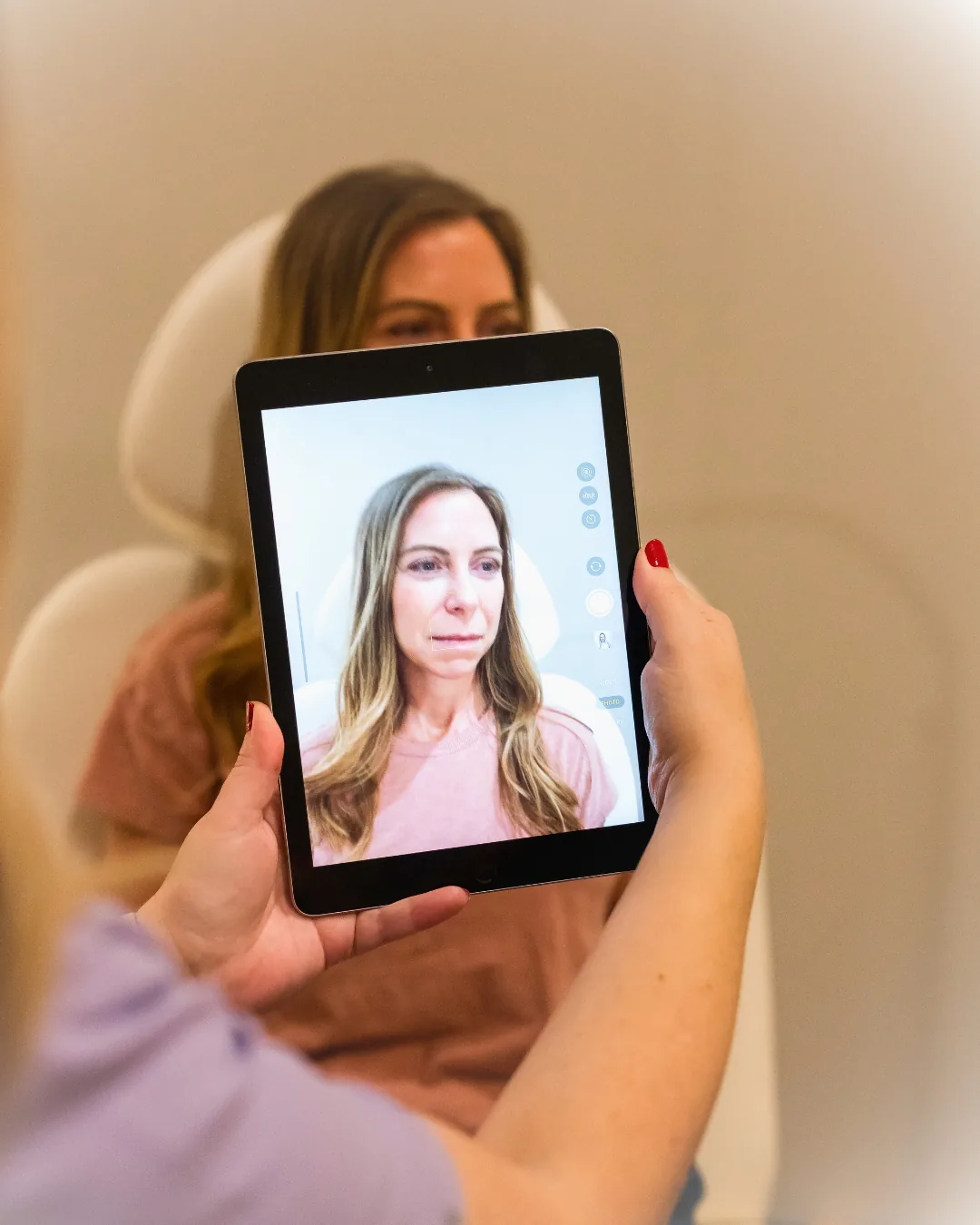 Esthetician holding tablet showing AI skin scan results to client during consultation at Banyan and Bamboo med spa South Lamar Austin TX